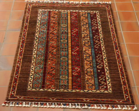 Bands of colour, sea blue, orange, red peach and burgundy go down the length of this piece.  Each are decoratied with floral motifs.  A wide border in a warm brown encases these.  This is broken up towards the outer edge with a narrow band of decorated red. 