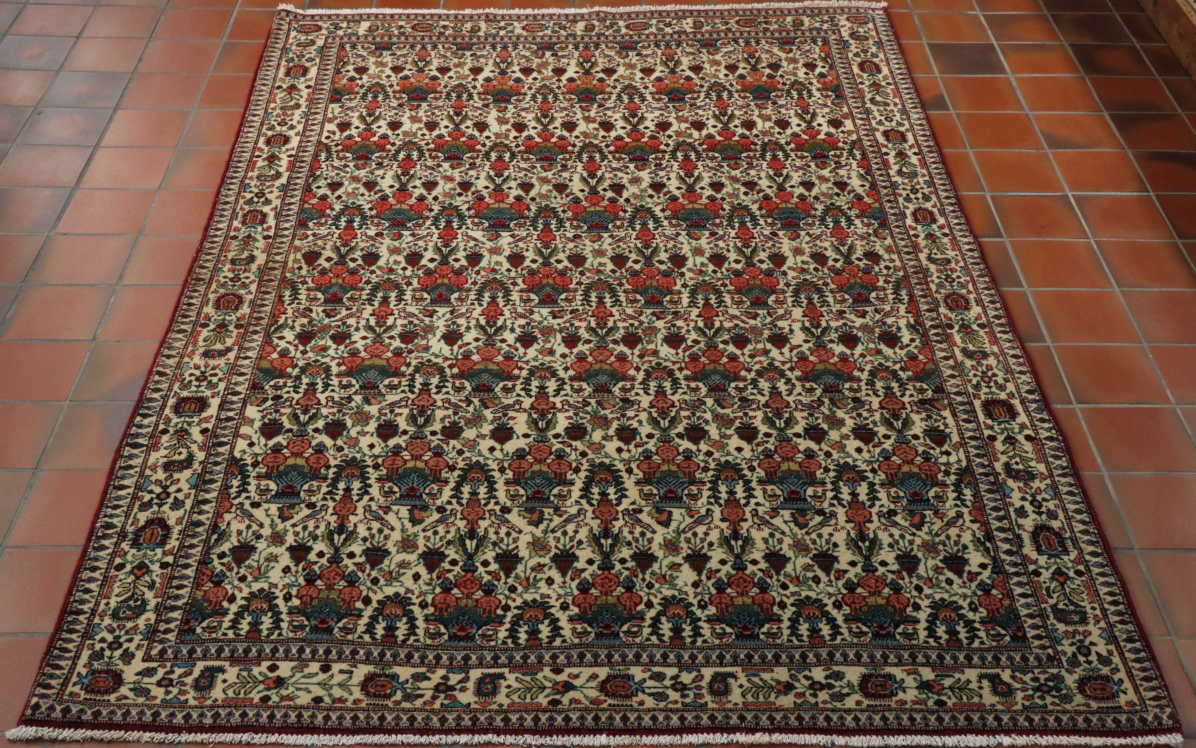 This Ghiasabad has a predominantly cream main ground and border with a complex pattern of flora, fauna and birds throughout it.  The colour pattern used in the decoration is red, red/pink, French blue, apple green and dark green.  The rug has a deep red edge to it which is picked out throughout the pattern work. 