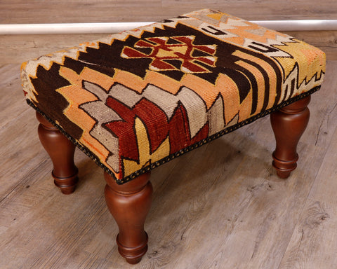 Theses Turkish Kilim stools often uses salvaged pieces.  This use produces an interesting look with the pattern being offset rather than centred, making the pieces unique and different.  This has an unusual mix of colours, very earthy tones consisting of dark brown, rust, yellow, orangey/yellow and mushroom.  The design is geometric shapes, almost leaf like which adds to this stool’s feeling of Autumn. 