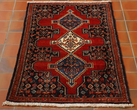 Central red shaped section on a dark blue background.  There are 3 medallions upon the central section.  Throughout there is floral decoration using a colour palette of blues, reds, creams and highlights in green. 